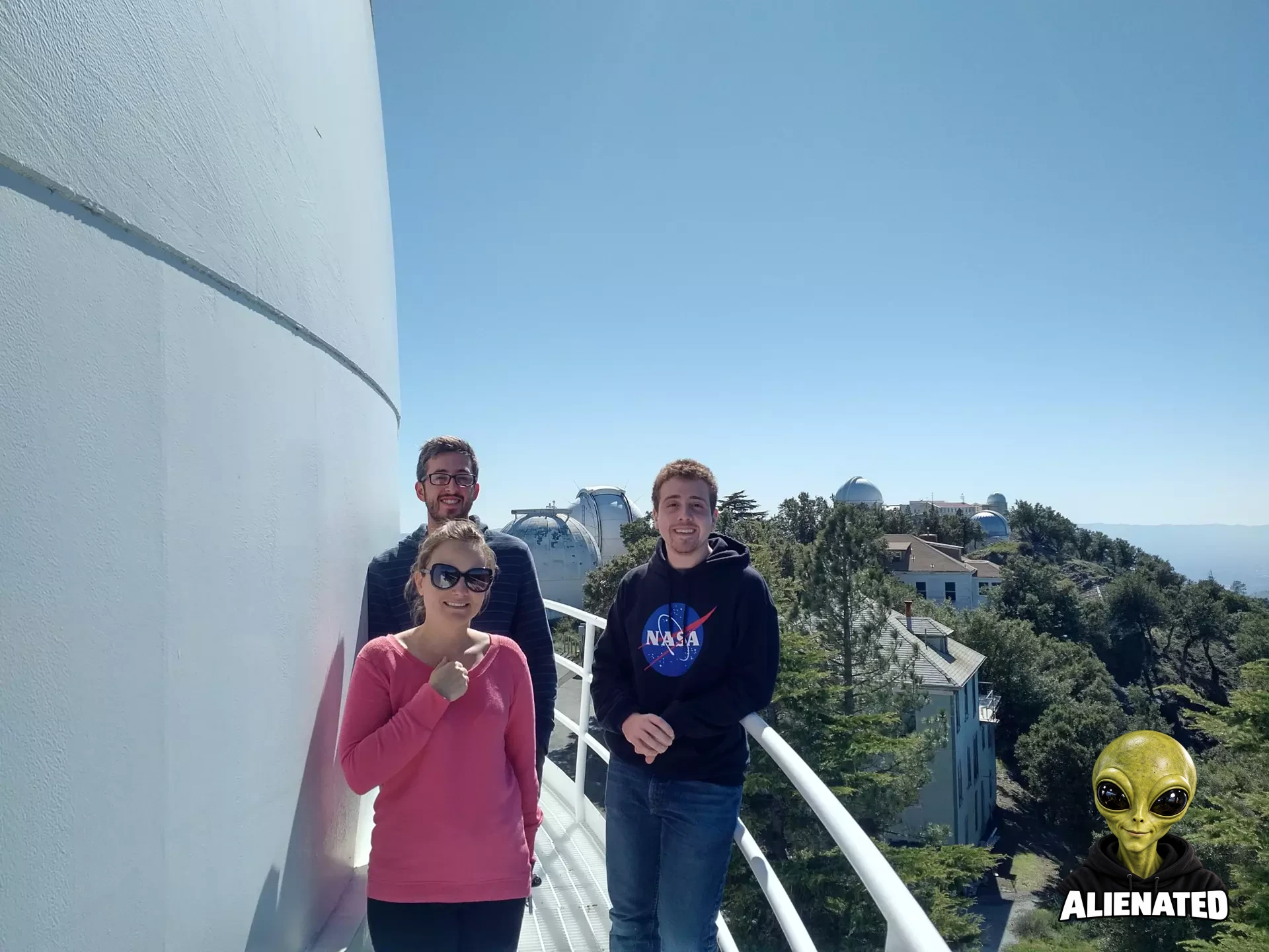 Richard Spolzino stands with his research adviser and a fellow grad student on an outdoor walkway at Lick Observatory, hills visible in the distance.